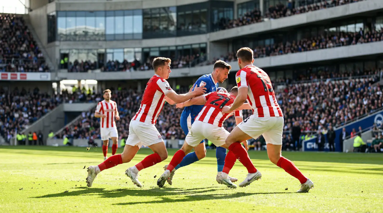 Fußballspieler in weißen Trikots beim taktischen Spielaufbau auf dem Rasen eines großen Stadions